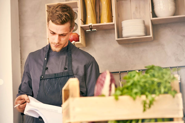 Gastronomen setzen auf regionale, saisonale Bioprodukte. (Foto: agefotostock, I. Hatz) Ein Koch prüft den Wareneingang anhand einer Liste.