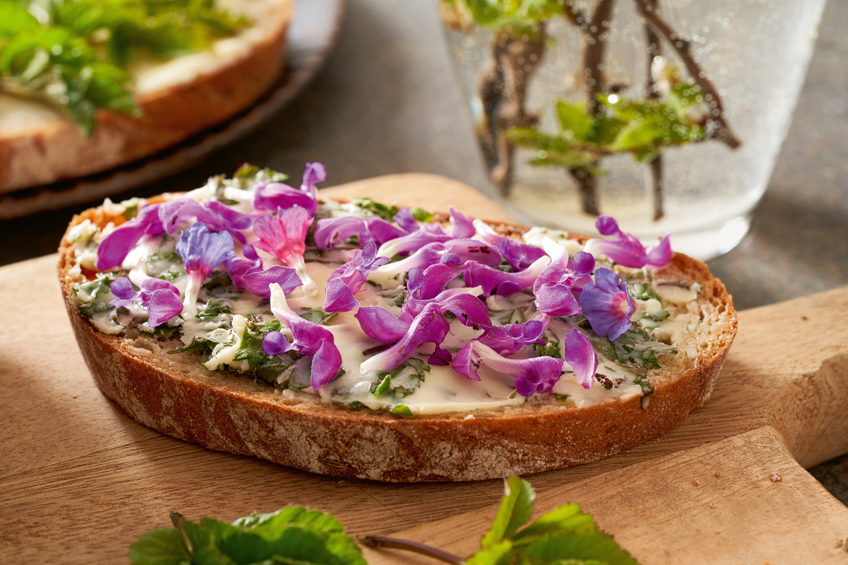 Blütenbutterbrot (Foto: 123RF, madeleinesteinbach) Ein zauberhaft schönes Brot bestrichen mit Blütenbutter. Kräftiges grün mischt sich mit Rosa- und Violetttönen.