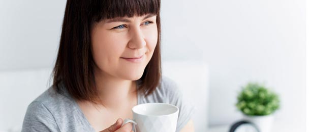 Eine Frau geniesst eine Tasse Tee.