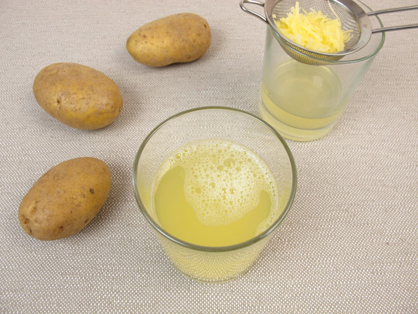 Kartoffelsaft hilft gegen Sodbrennen (Foto: 123RF, heikerau) Frischer Kartoffelsaft im Glas, neben weiteren Kartoffeln auf einem Tisch.