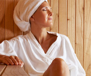 A.Vogel: Wellness-Tipps für die Wechseljahre (Foto: 123RF, Stylephotographs) Eine reife Frau entspannt in einer Holzsauna.