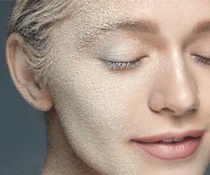 A.Vogel: Hilfe bei Psoriasis (Foto: 123RF, puhhha) Das Gesicht einer Frau ist mit feinem Sand bedeckt. Ihr Augen sind verschlossen. Sinnbild für trockene Haut.