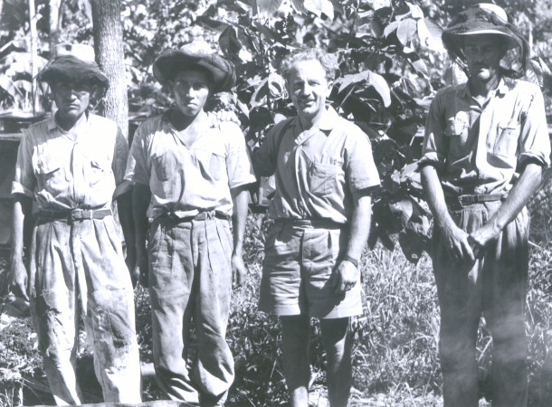 Undatierte Aufnahme von Alfred Vogel, vermutlich in Südamerika auf einer Plantage. Alfred Vogel mit Indigenen auf einer Plantage