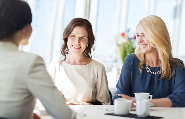 Eine entspannte runde Frauen unterhält sich beim Kaffee.